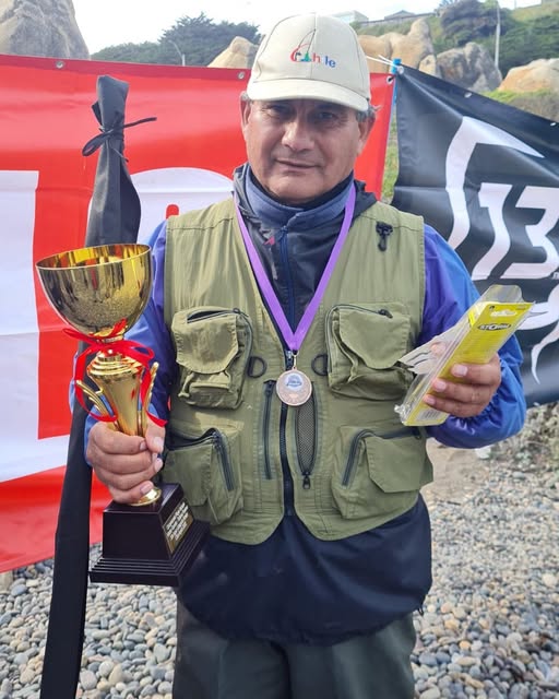 Integrante del Club Albatros con copa y medalla